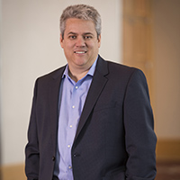 Portrait of a professional man posing with a smile in an office setting.