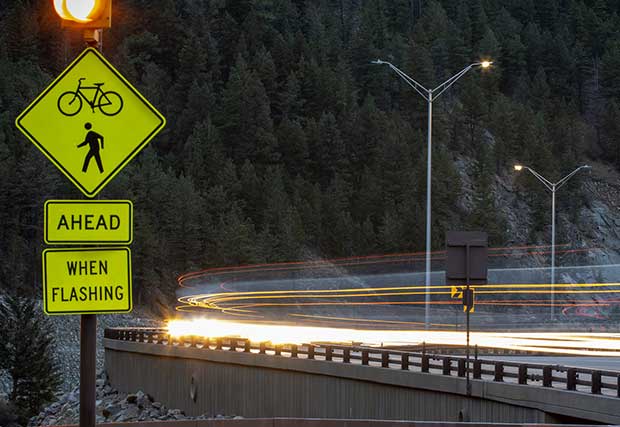 An image of a road sign with cars going by 