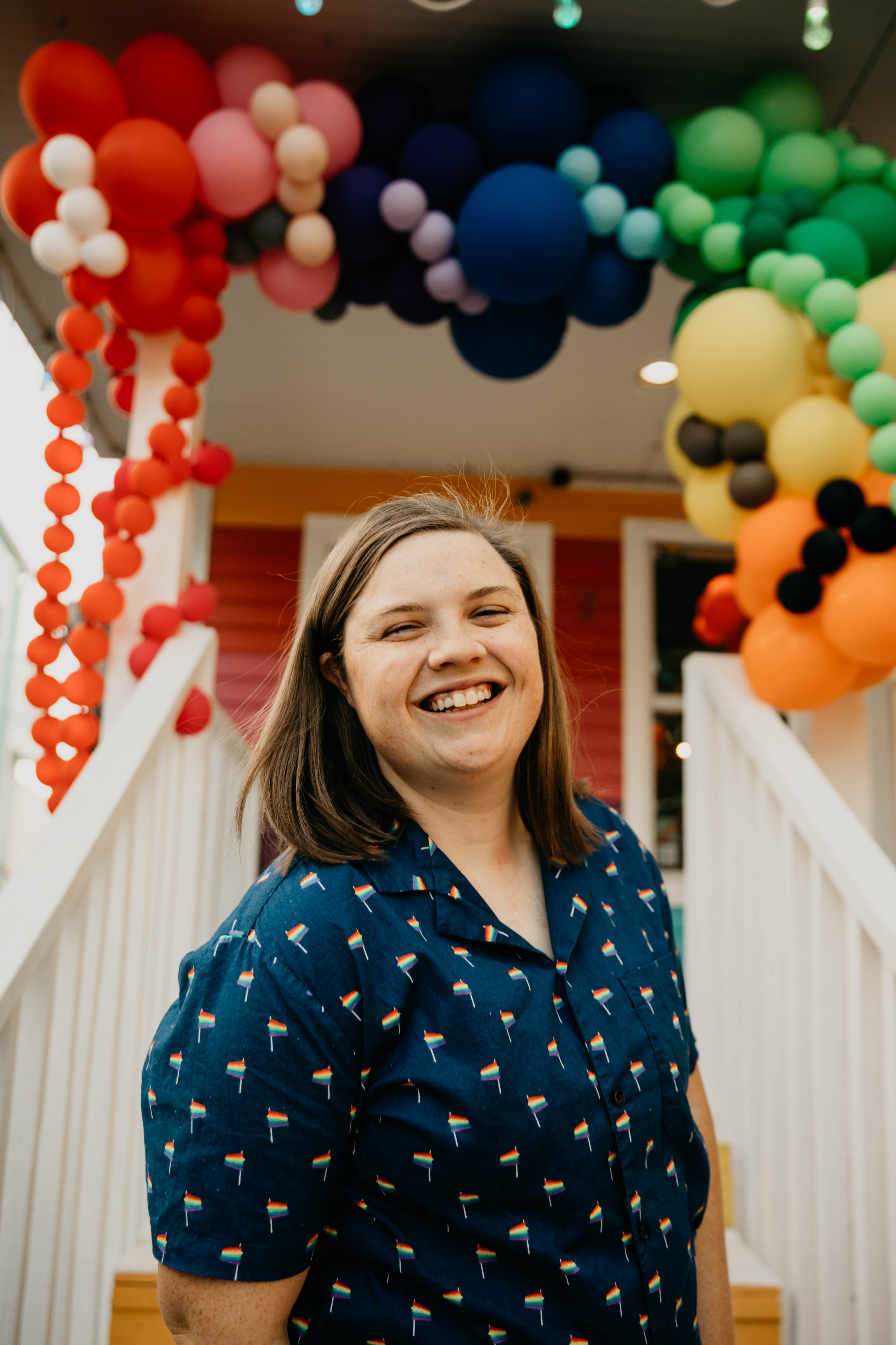 Jessie standing in front of rainbow balloons