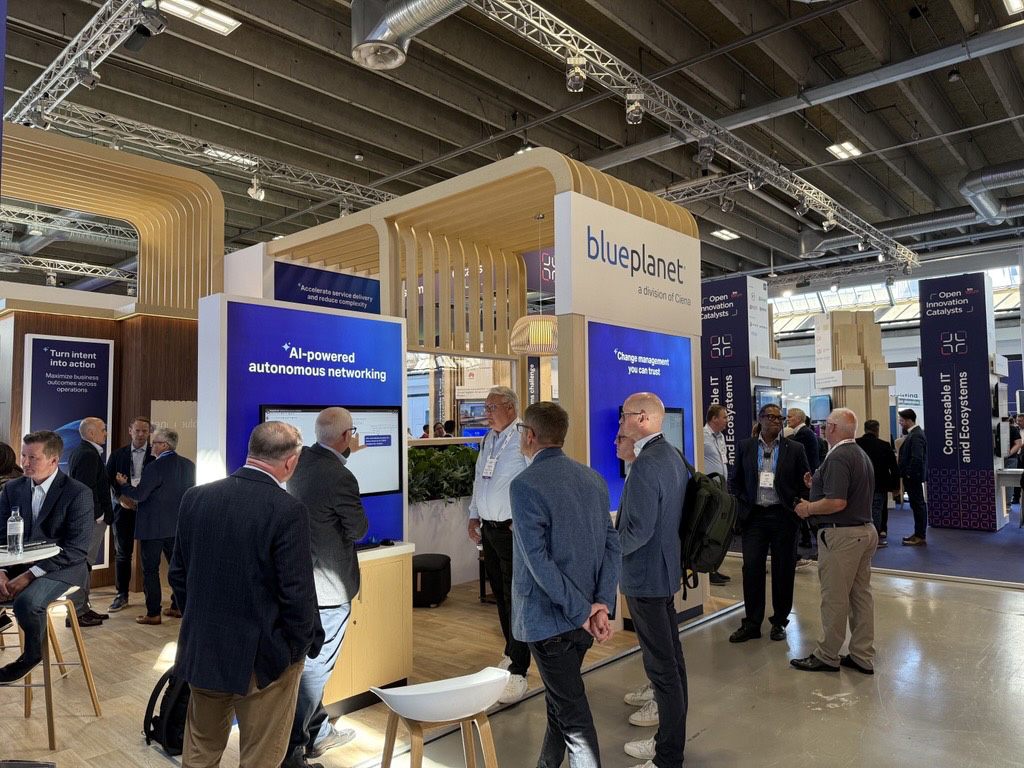 Attendees engage with demonstrations and discuss solutions at the Blue Planet exhibition booth featuring AI-powered autonomous networking displays.