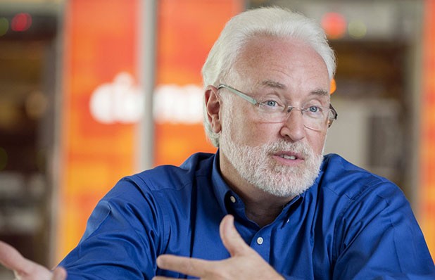 An image of a man engaged in conversation, speaking passionately. He is gesturing with his hands and appears to be deeply involved in the discussion, conveying enthusiasm and a strong communication presence.