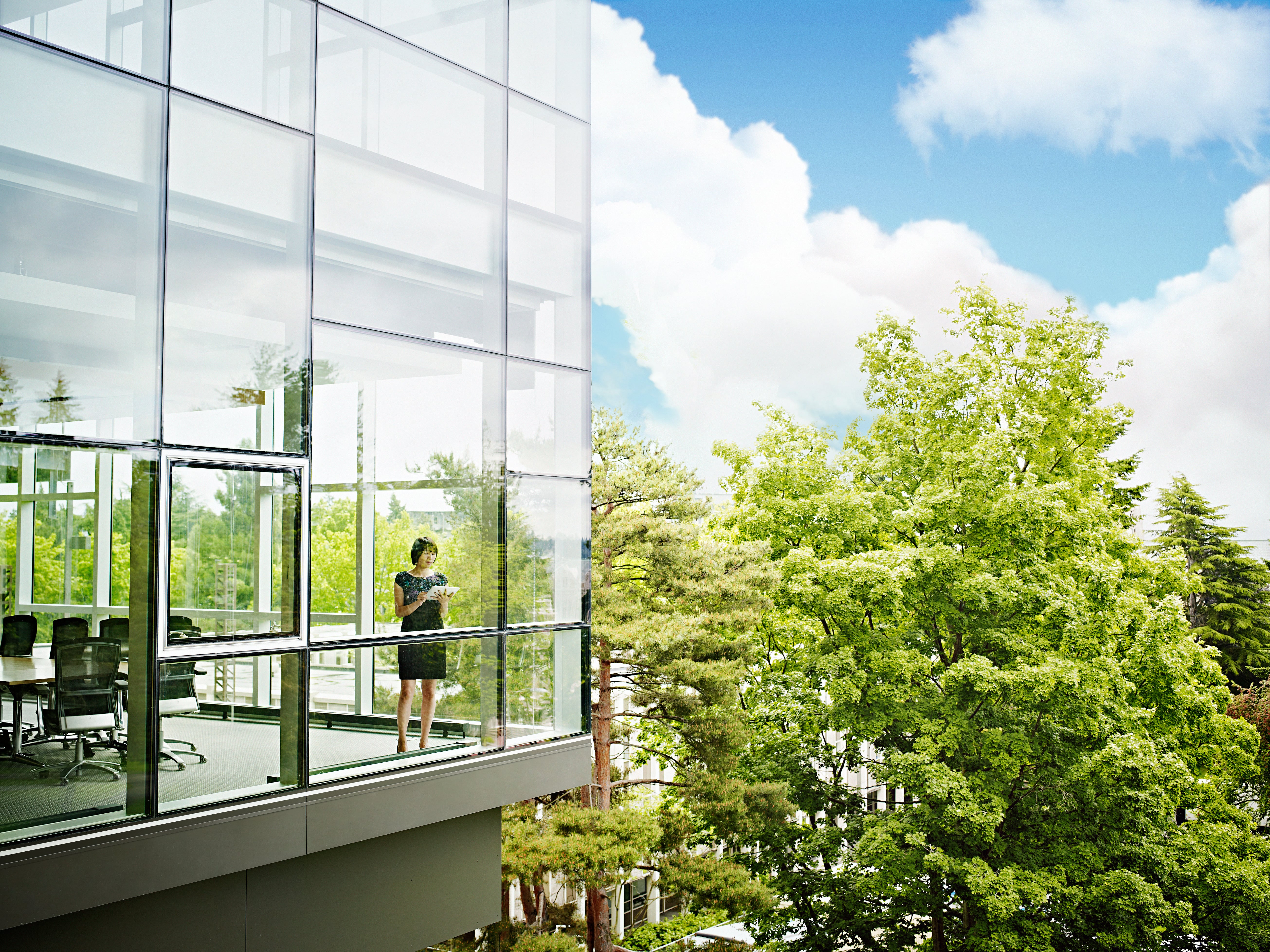 a woman looking out of a window of a conference room