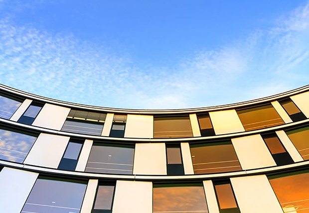 An image of a curved building with a view of the sky. The building's unique architecture and the open sky above create a visually striking composition, showcasing modern design and the beauty of the built environment