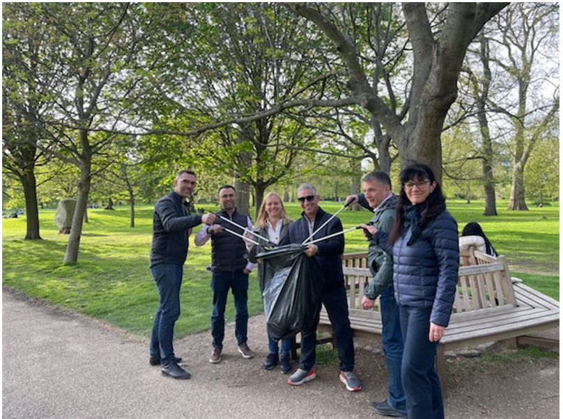 6 people placing trash into a trashbag