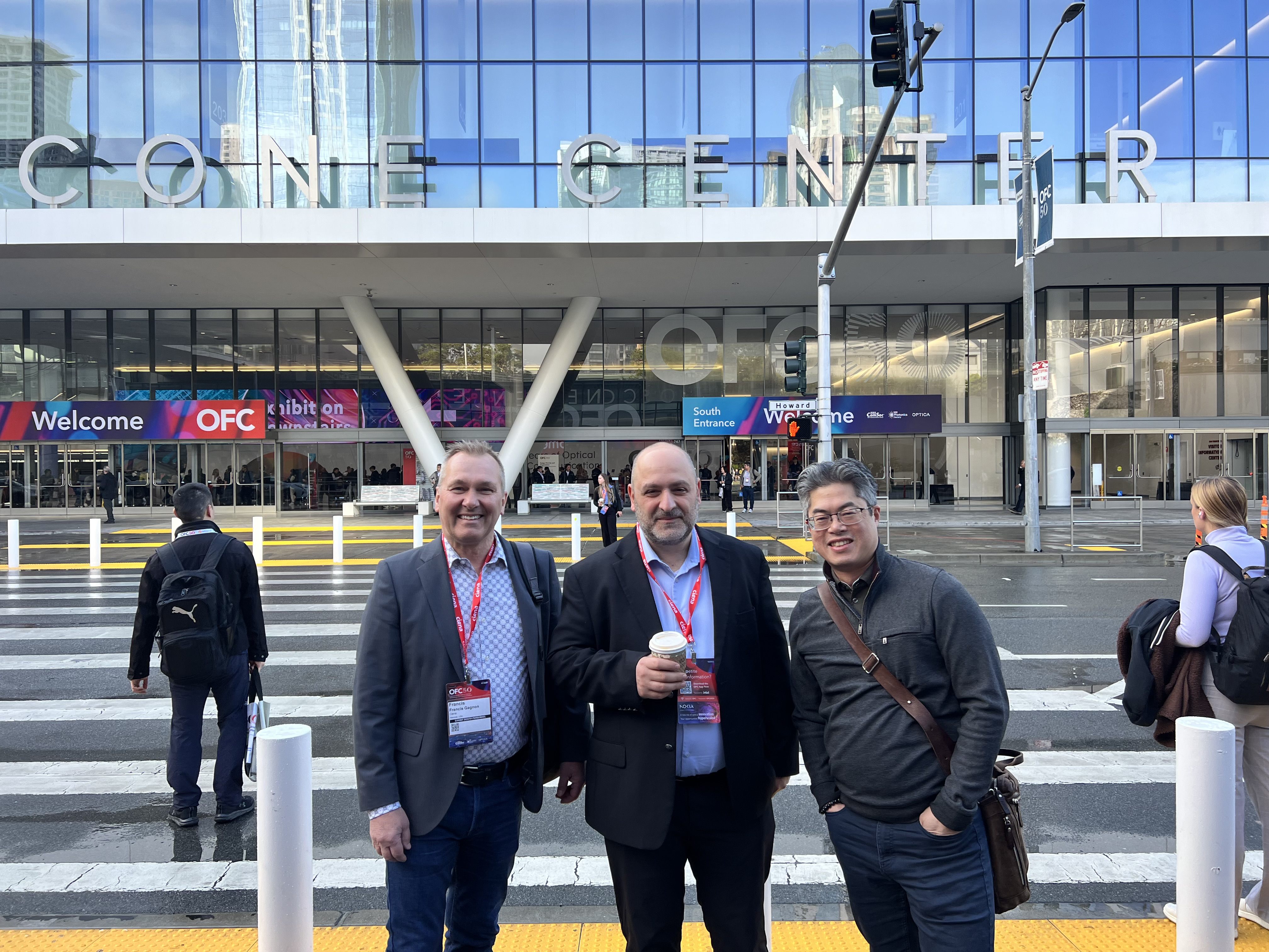 three men standing outside of a building