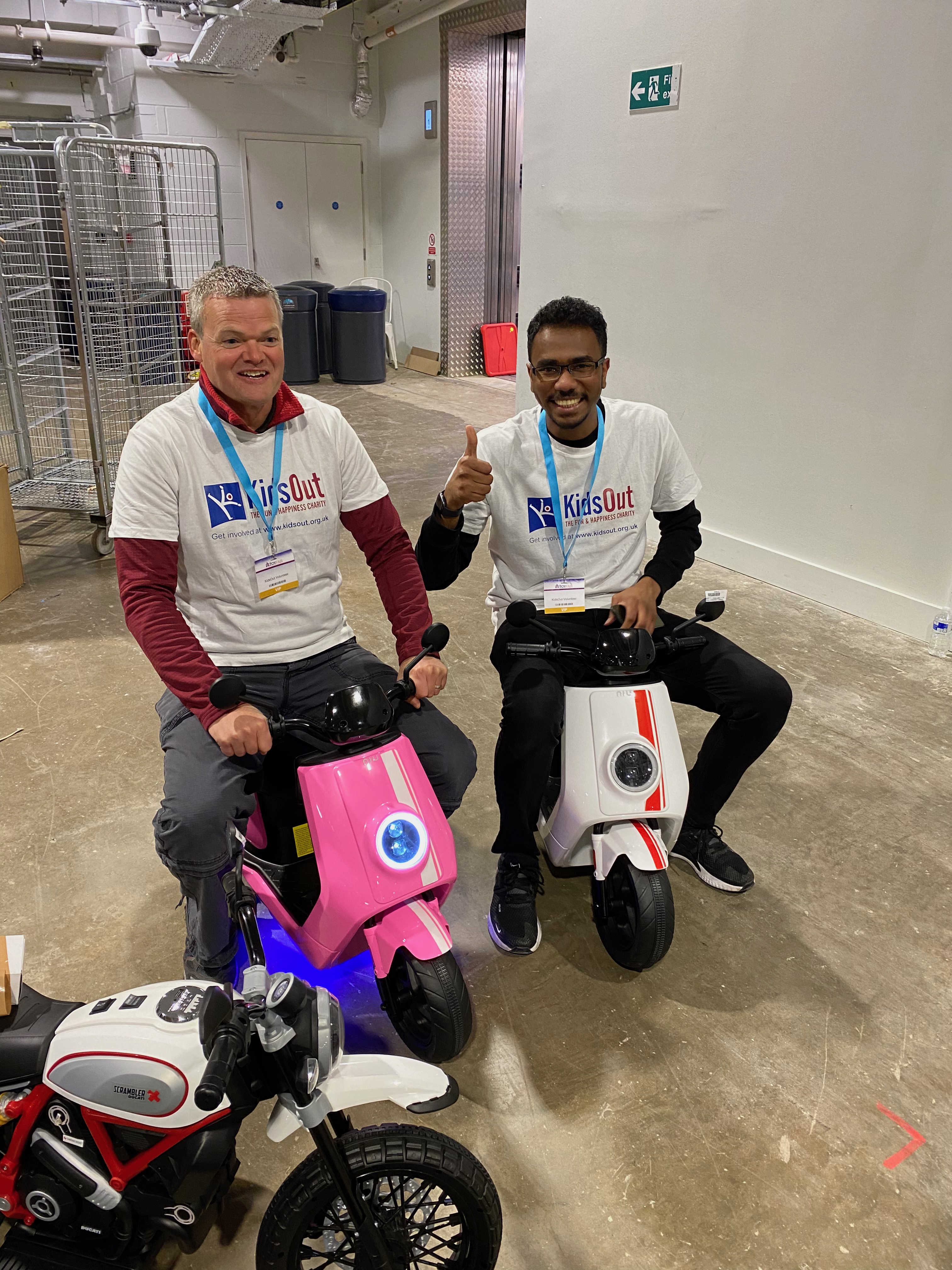 Two men on children's toy motor bikes