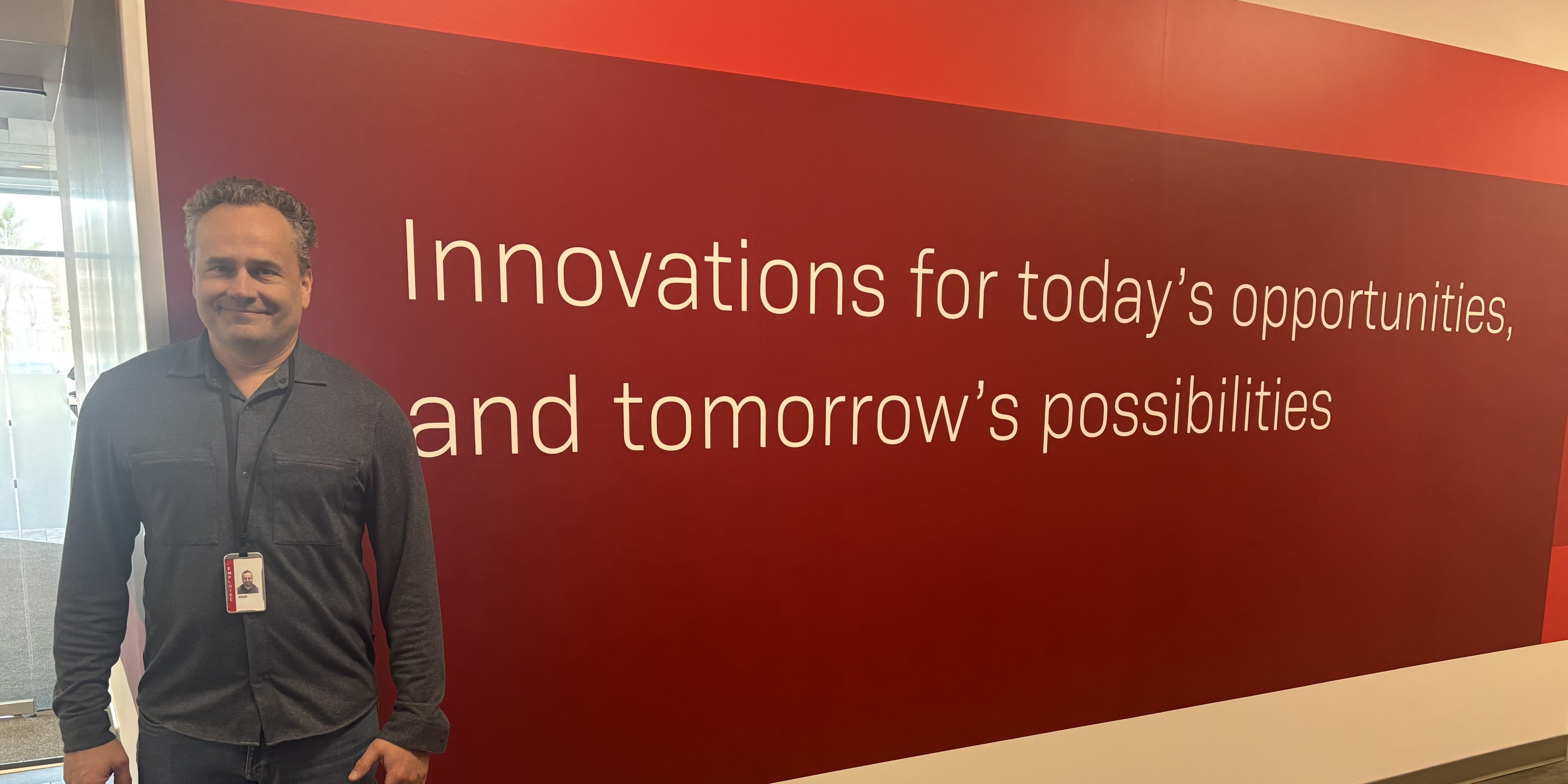 David standing by a sign promoting innovation in the office
