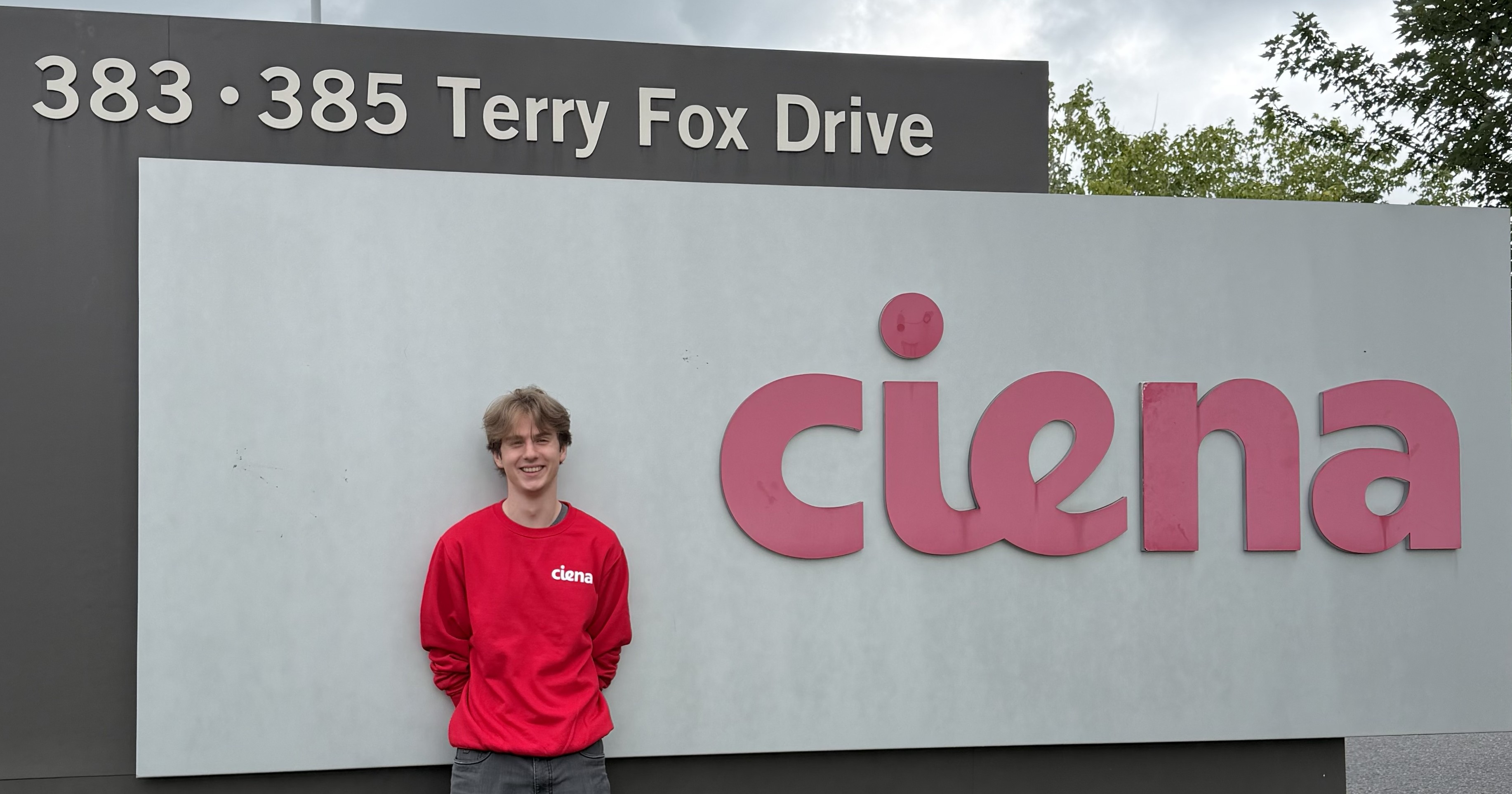 Mattias standing in front of the Ciena sign at the Ottawa office