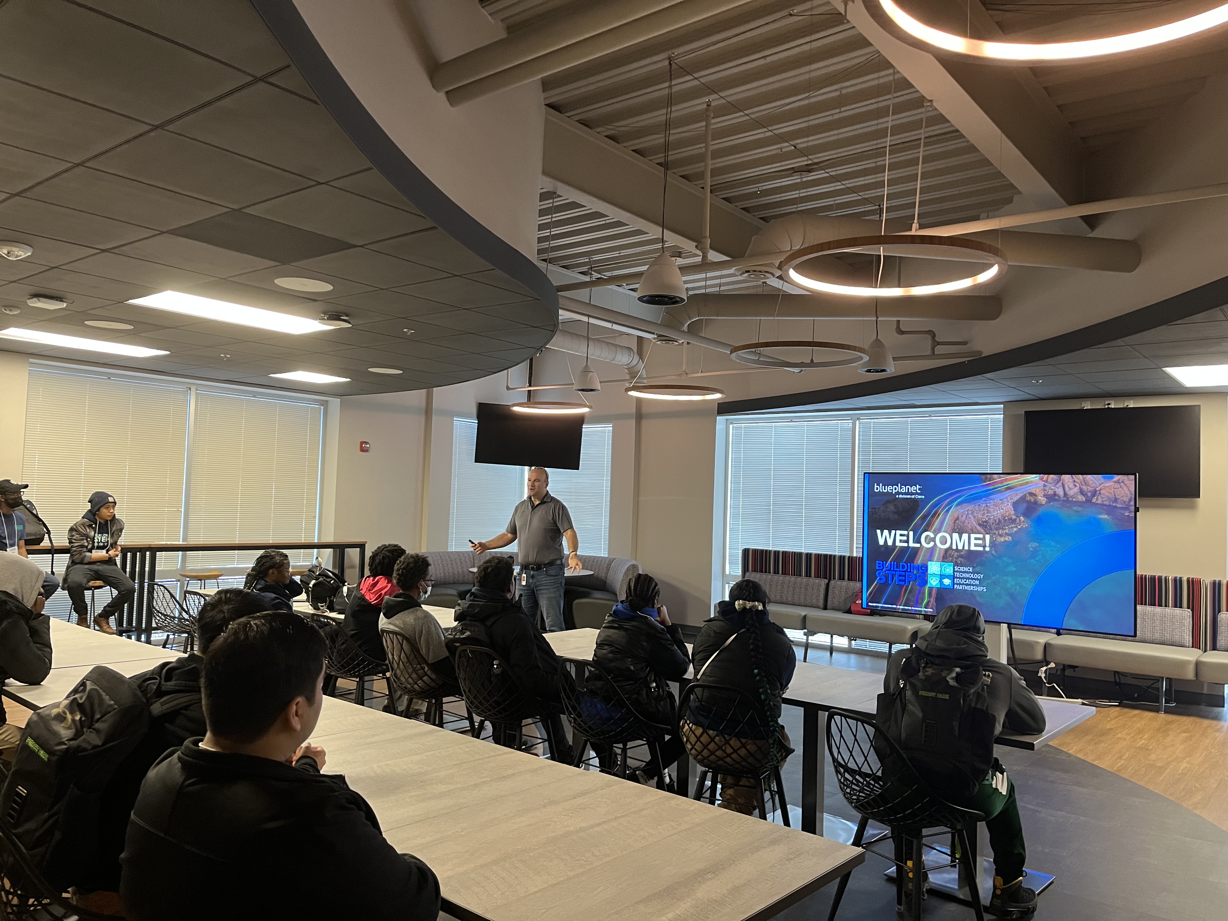 One man presenting to a group of students sitting 