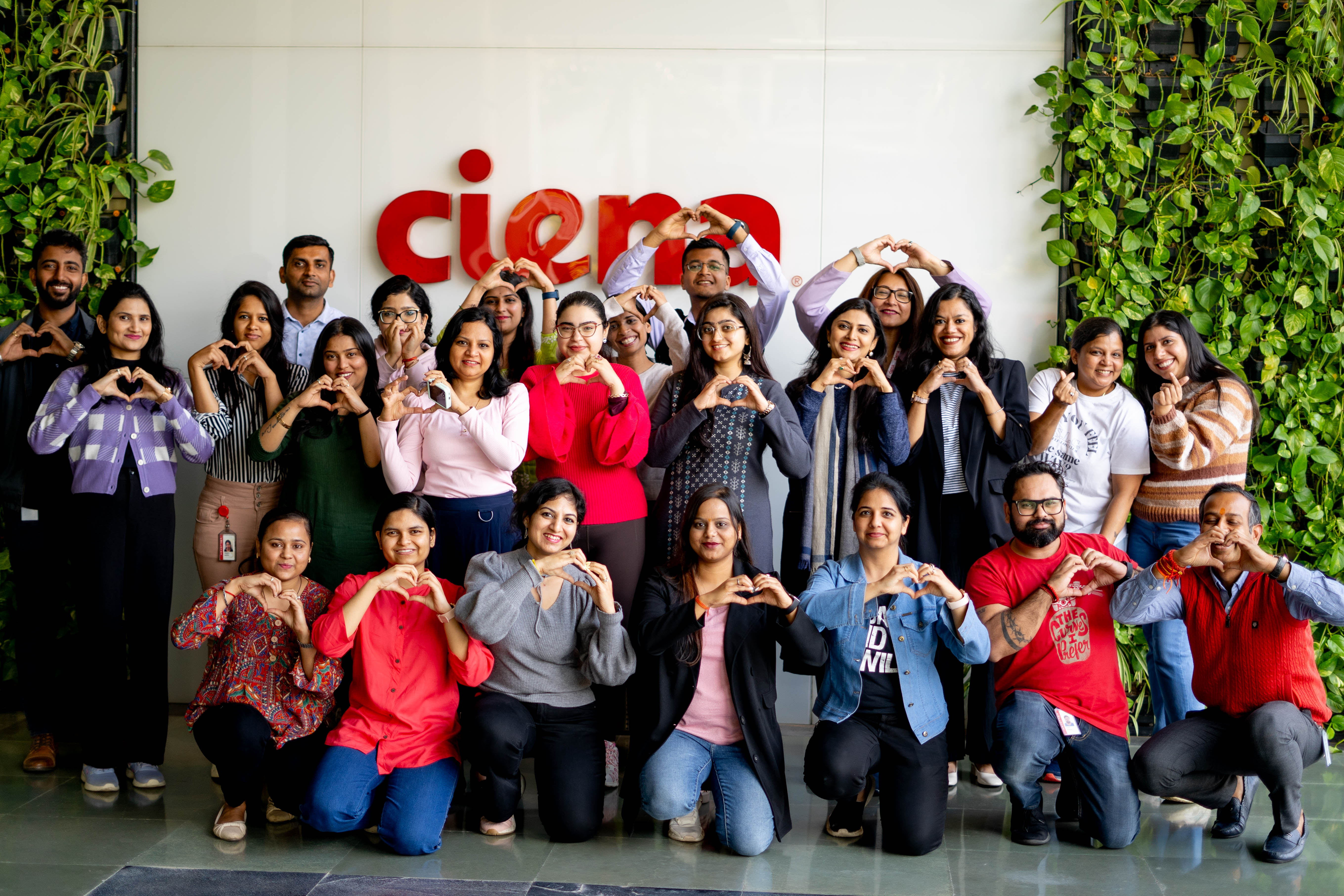 A group  of women and men holding their hands in the shape of a heart