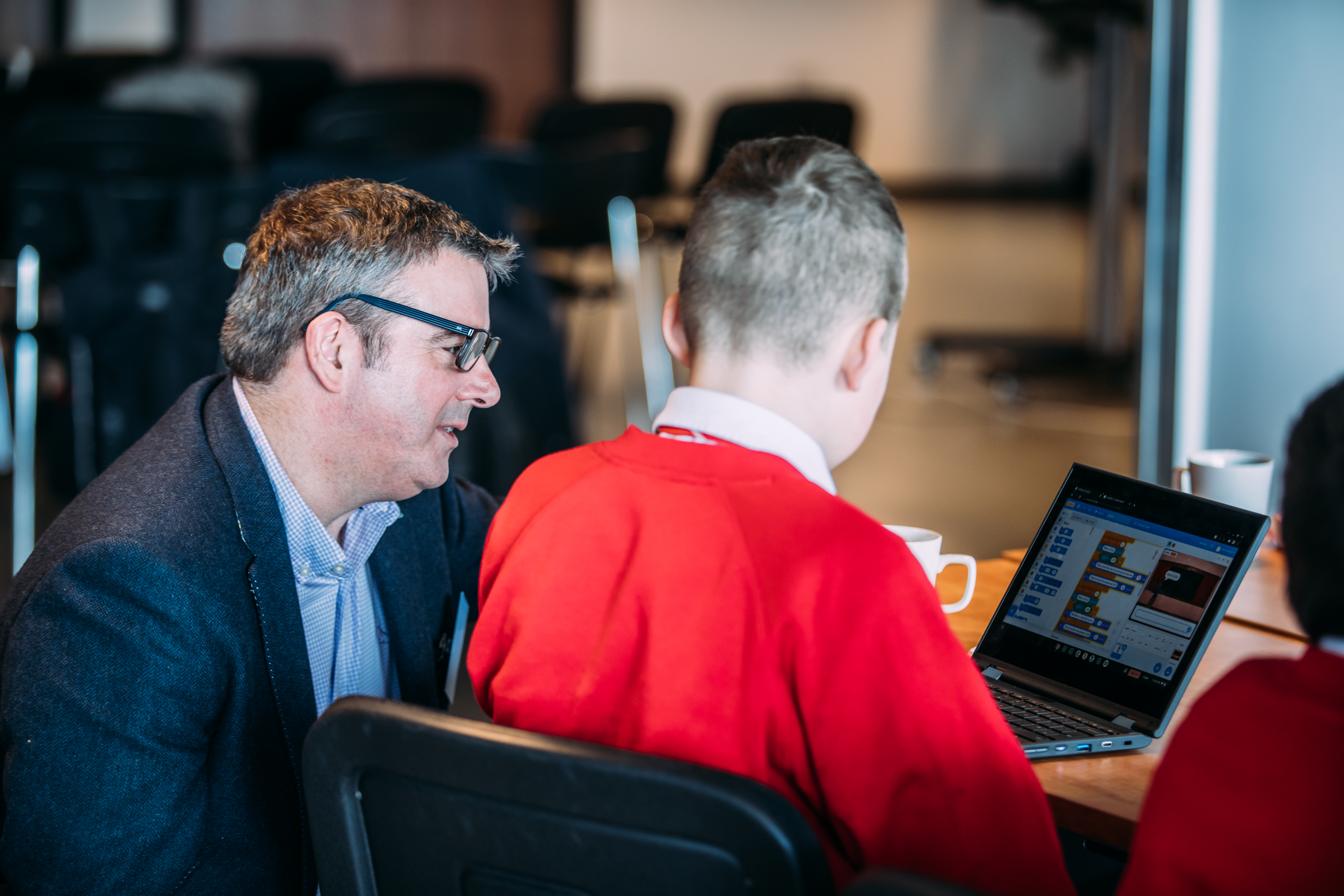 Man helping a student on his computer 