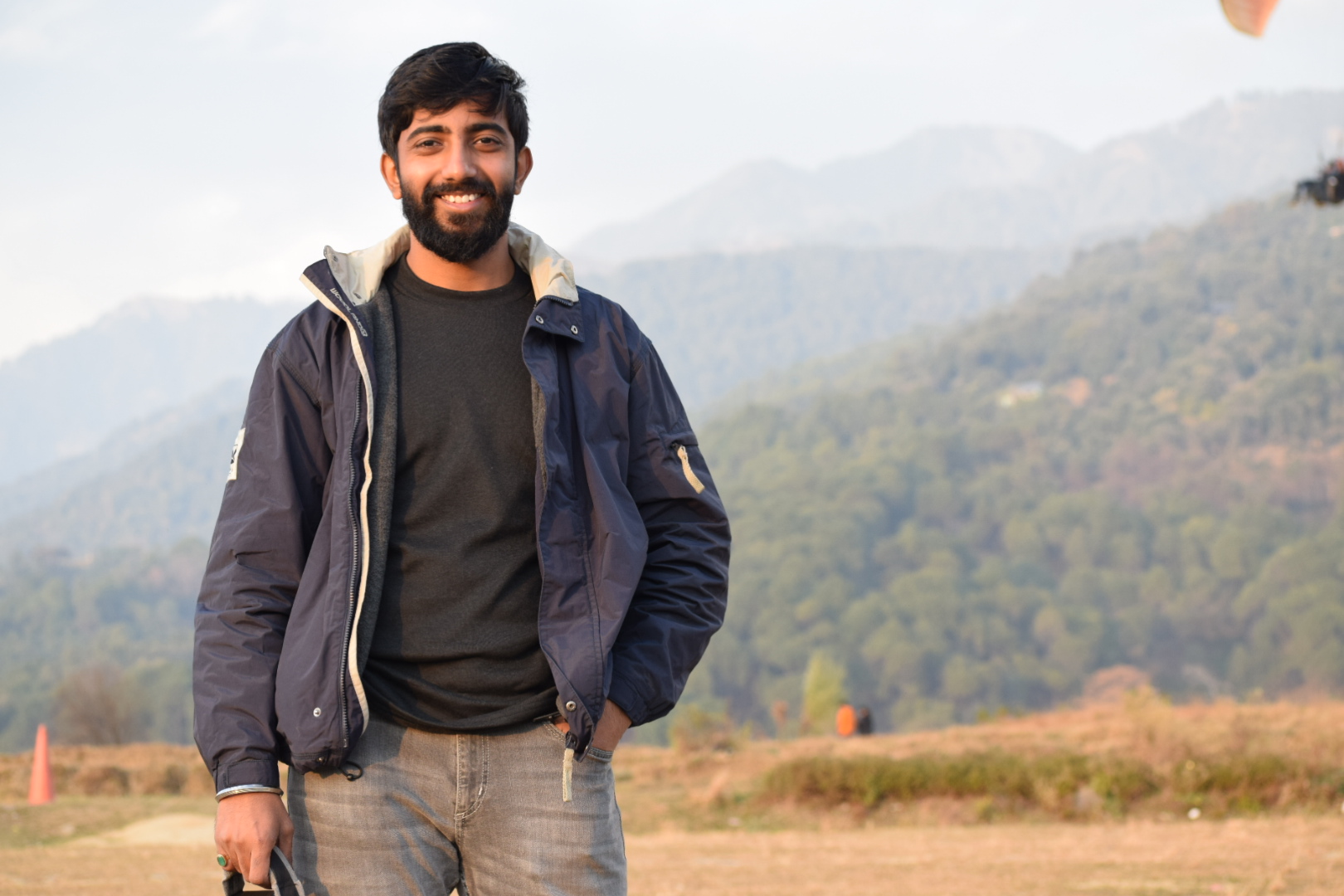 Man smiling at the top of a mountain 